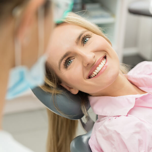 Woman in a dental chair is happily smiling
